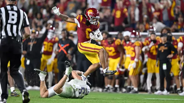USC Trojans Football wide receiver Makai Lemon leaps over Northwestern Wildcats defender