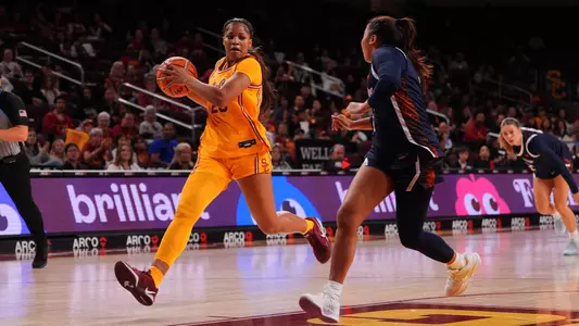 Kara Dunn wears a gold jersey as she drives to the basket.