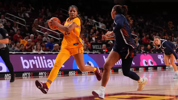Kara Dunn wears a gold jersey as she drives to the basket.