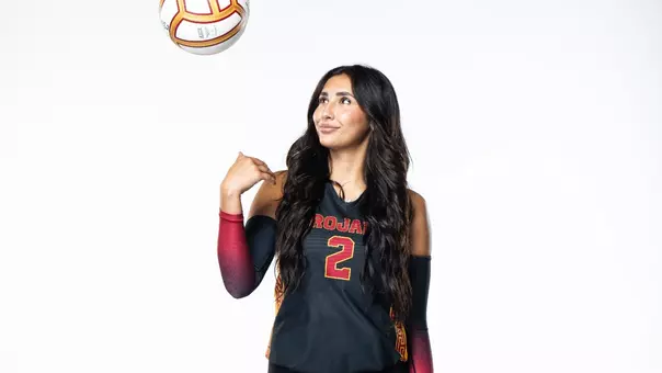 USC women's volleyball outside hitter London Wijay (in a black uniform) tosses the ball into the air during a media shoot