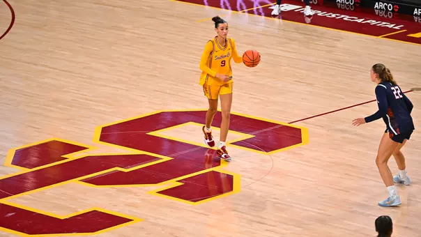 Jazzy Davidson brings the ball down the court in a gold jersey.