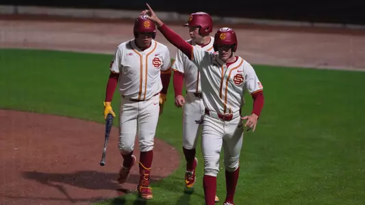 Dean Carpentier, Richard Tejeda, and Kade Higgins celebrate after scoring 3 runs against George Washington on Opening Day.
