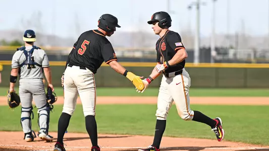 Jack Basseer and Adrian Lopez high five as Basseer runs back to the dugout.