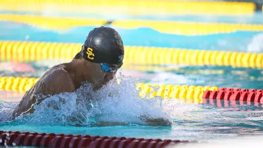 A Trojan swimmer takes a breathe while swimming breaststroke in the pool.