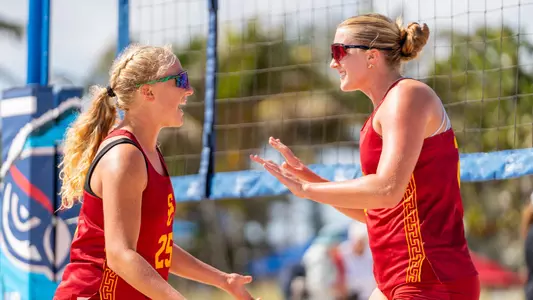 USC beach volleyball sophomores Kaileigh Truslow and Madison Goellner celebrate scoring a point in a match against No. 15 Stetson in the FAU Beach Invitational on Pompano Beach, Fla.