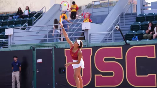 Jana Hossam hits a tennis ball above her head on a return.