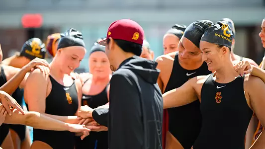 USC players and head coach Casey Moon huddle up for a cheer after a game at Uytengsu Aquatics Center