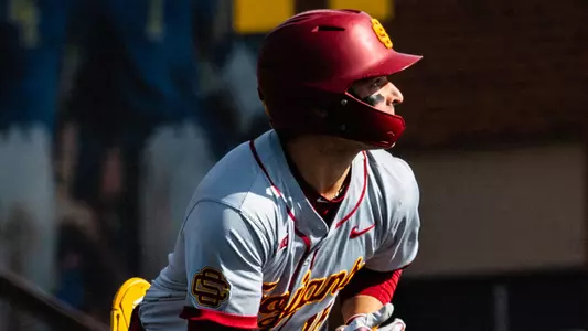 Brayden Dowd watches a ball fly as he runs from home plate.