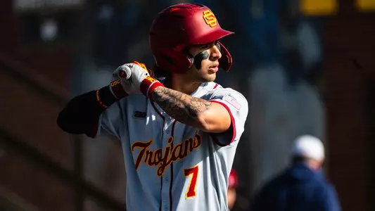 Abbrie Covarrubias stands in the box ready for an at-bat, wearing USC baseball's gray jersey with Trojan script.