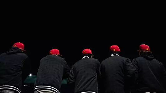 Backs of players from the dugout.