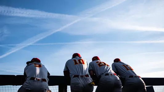 Team on railing in the dugout at Michigan.