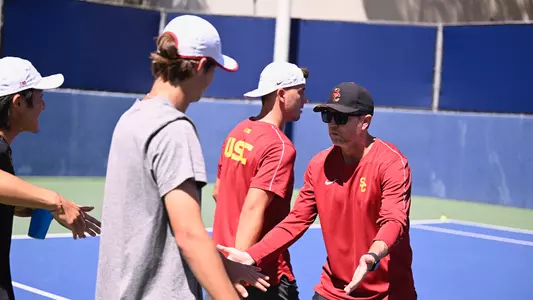 Head coach Brett Masi high fiving players ahead of the UCLA match