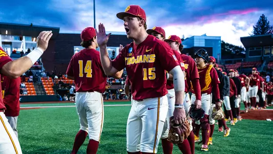 Ethan Hedges high fives with teammates after a win over Saint Mary's in the Corvallis Regional.
