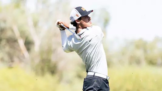 Nicolas Dominguez takes a swing with an iron during a golf tournament.