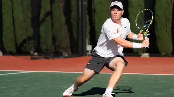 Max Exsted hits a return on the tennis court.