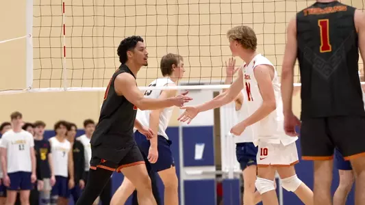 USC men's volleyball outside hitter Kahale Clini and libero Johnny Dykstra high five during a match at the Freed Center for Leadership in Costa Mesa