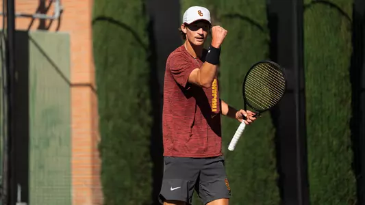 Niels hoffmann pumps his fist while holding a tennis raqcuet