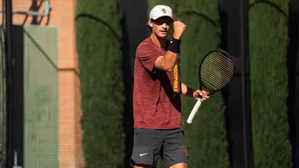 Niels hoffmann pumps his fist while holding a tennis raqcuet
