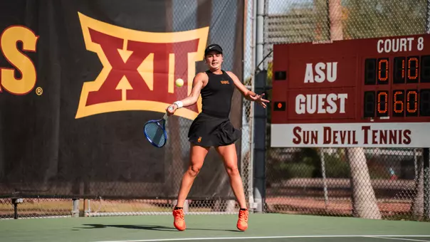 Eugenia Zozaya hits a return on tennis court.