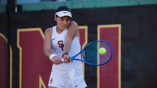 Eugenia Zozaya hits a tennis ball using a racquet.