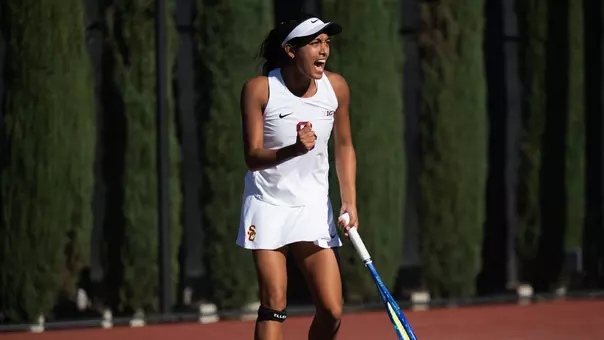 Krisha pumps her fist after winning a point on court
