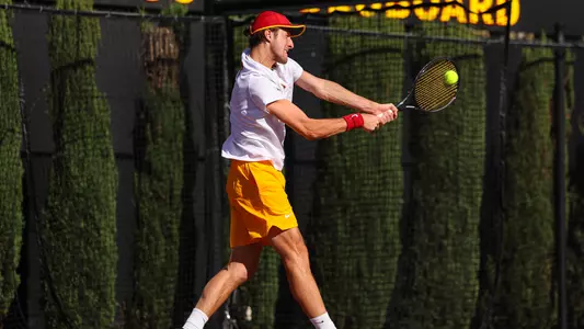 Branko Djuric uses a tennis racket to hit a ball in air.