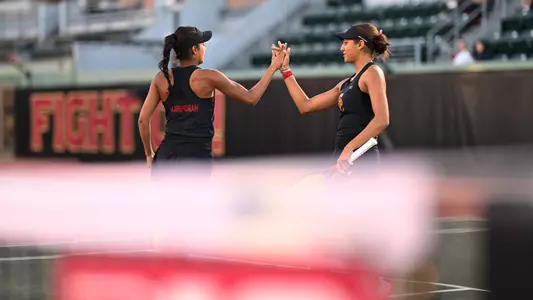Two Trojans high five on the basketball court
