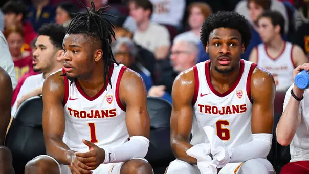 Isaiah Collier and Bronny James sit next to each other on the bench
