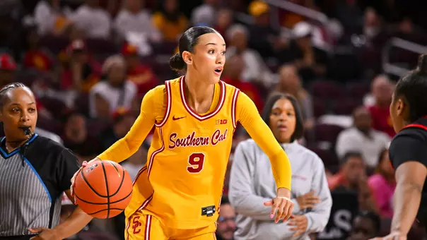 Jazzy Davidson wearing a gold jersey dribbles past a defender.