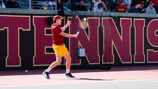 Andrin Casanova makes contact with ball using his racket on tennis court