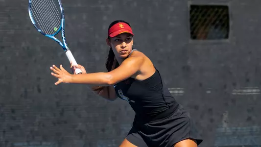 Dani borruel hits a return on court for usc women's tennis