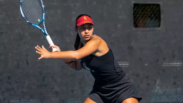 Dani borruel hits a return on court for usc women's tennis