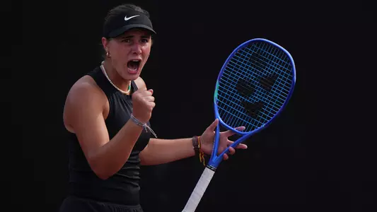 Eugenia Zozaya celebrates with a scream and fist pump while holding racket