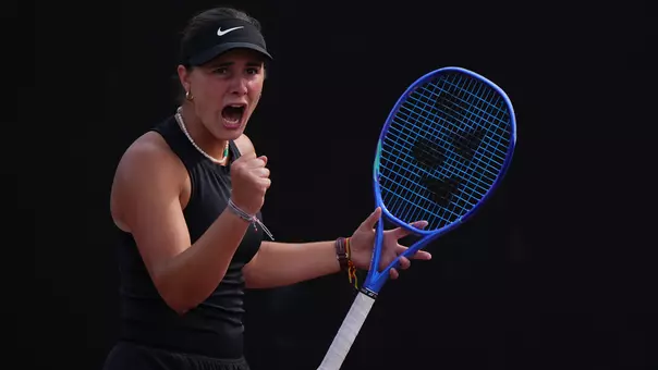 Eugenia Zozaya celebrates with a scream and fist pump while holding racket