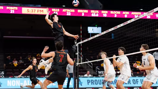 USC men's volleyball middle blocker Parker Tomkinson goes up to attack a quick-set ball from Ryan Sprague during a match against Menlo at Galen Center.