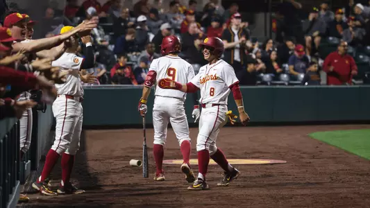 Kevin Takeuchi returns to the dugout after scoring against Illinois.