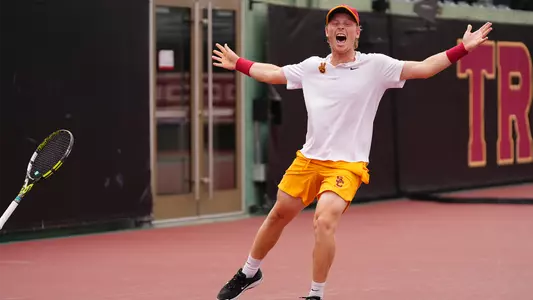 Max Exsted throws his hands out and celebrates as the Trojans win.