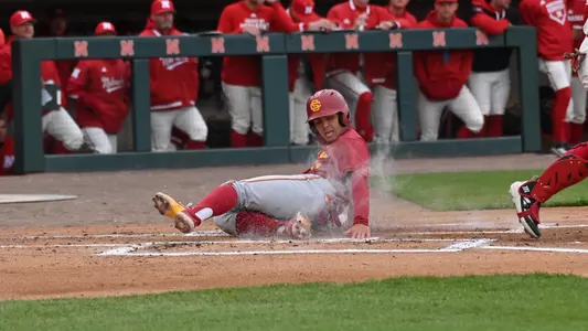 Kevin Takeuchi slides into home plate and scores a run during the first game against Nebraska.