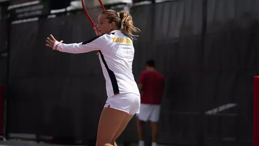 Immi Haddad hits a return with her tennis racket