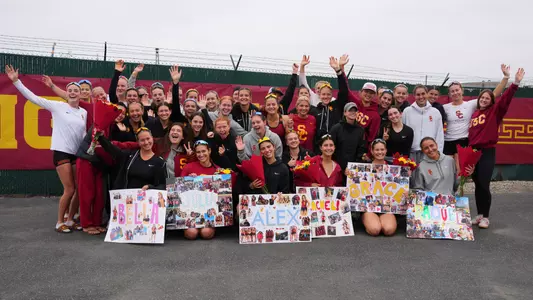 USC women's rowing poses with its seniors and their signs after a race