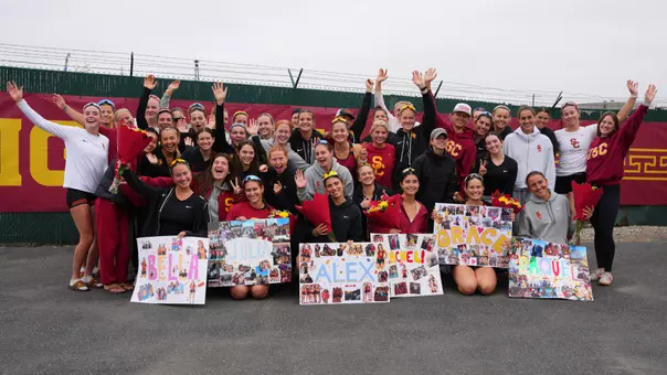 USC women's rowing poses with its seniors and their signs after a race