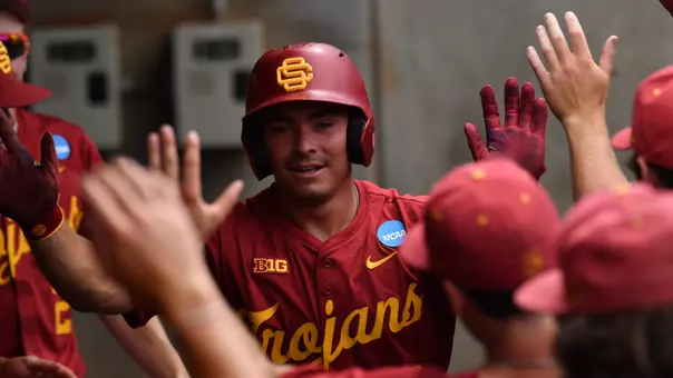 Walter Urbon high-fives teammates in the dugout after hitting a grand slam against Lamar