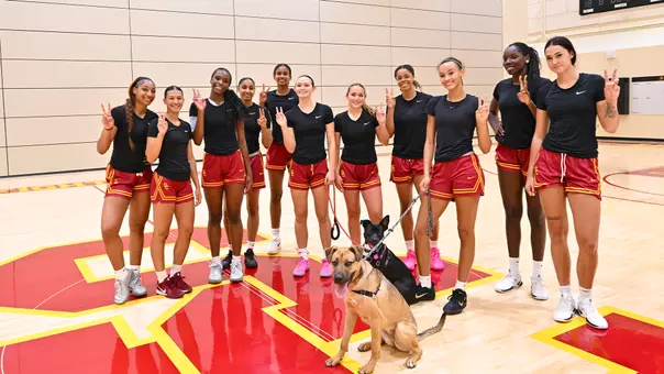 Usc wbb poses with dogs from the best friends animal society of Los Angeles.