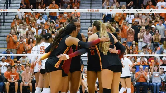 USC women's volleyball players huddle on the court during a match against Texas at Gregory Gymnasium in Austin, Texas.