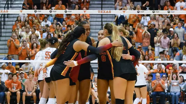 USC women's volleyball players huddle on the court during a match against Texas at Gregory Gymnasium in Austin, Texas.