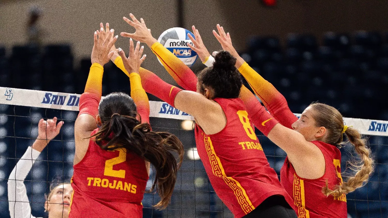 USC women's volleyball players London Wijay, Mia Tvrdy, and Abigail Mullen go up to block an attack by the Toreros during a match at Jenny Craig Pavilion in San Diego, Calif.