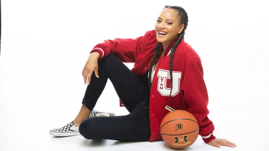 Daneesha Provo sits with a ball in her lap while laughing