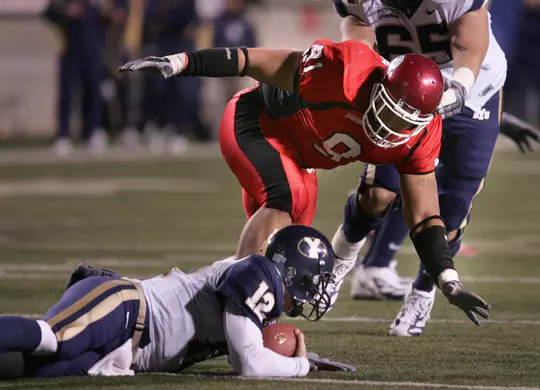 Utah's Johnathan Fanene over a downed BYU quarterback, John Beck.