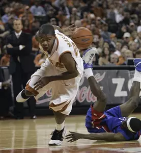 Texas guard Justin Mason, left, attempts a pass behind his back after taking the ball while fouling UT Arlington guard Rodrick Epps, right, during first-half action in a men's college basketball game Tuesday in Austin, Texas. (AP Photo/Harry Cabluck)