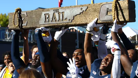 Mocs Hoist the Rail Rivalry Trophy.